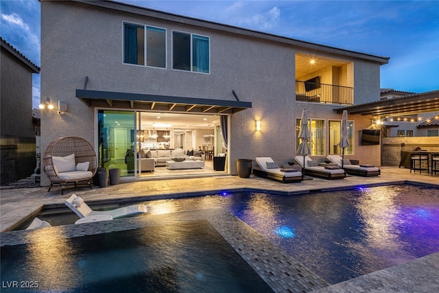 rear view of house with a pool with hot tub, an outdoor living space, and a patio