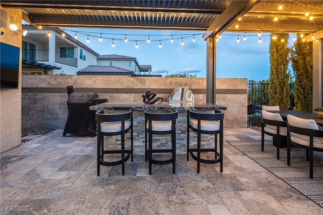 view of patio / terrace featuring exterior kitchen and a pergola