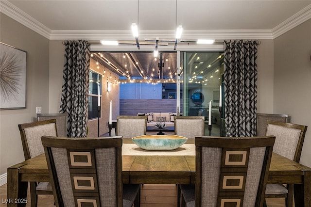 dining area with an inviting chandelier, crown molding, and wood-type flooring