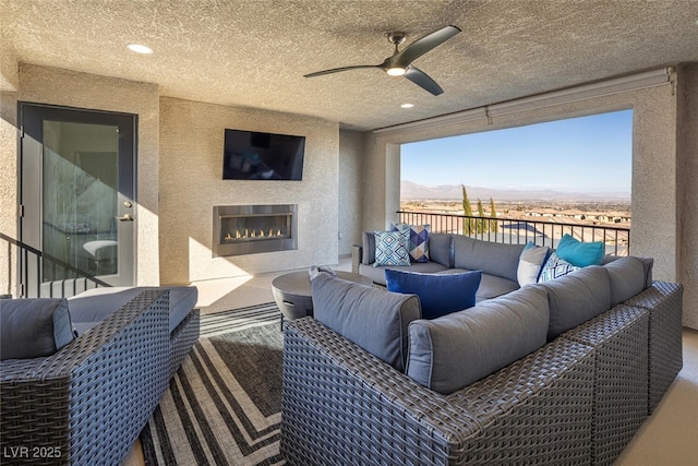 balcony with ceiling fan and a textured ceiling