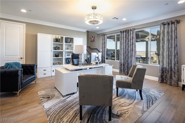 home office with crown molding and light hardwood / wood-style flooring