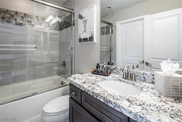 full bathroom with toilet, vanity, and bath / shower combo with glass door