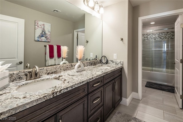 bathroom with vanity and shower / bath combination with glass door