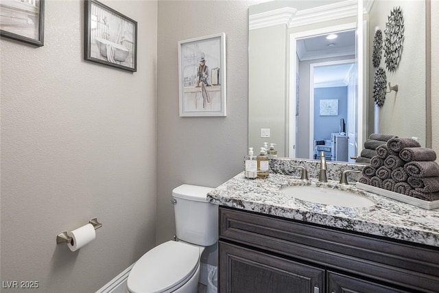 bathroom with vanity, ornamental molding, and toilet