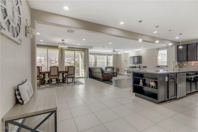 kitchen featuring tasteful backsplash, hanging light fixtures, light stone countertops, and a center island