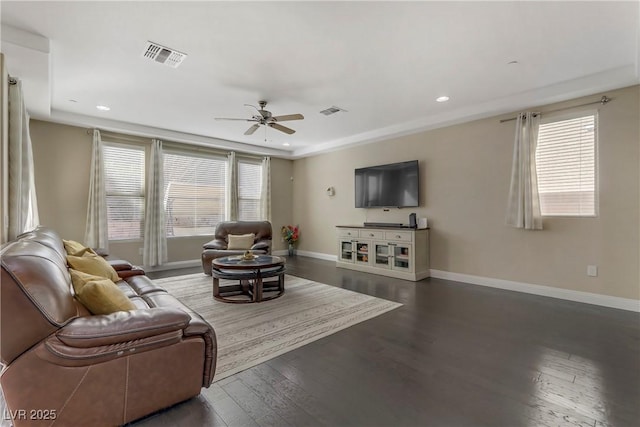 living room featuring a wealth of natural light, dark hardwood / wood-style floors, and ceiling fan