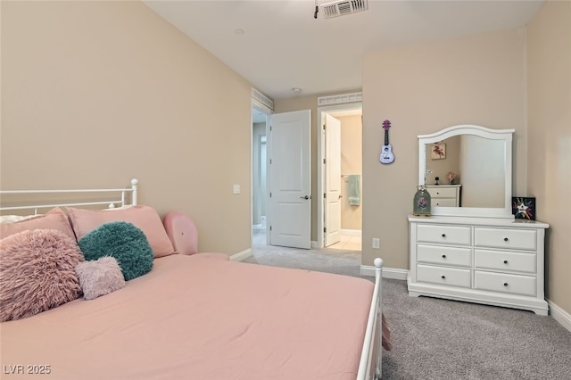 bedroom featuring ensuite bathroom and light carpet