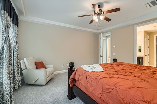 carpeted bedroom with a tray ceiling and ceiling fan