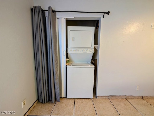 laundry area featuring stacked washer and dryer and light tile patterned floors