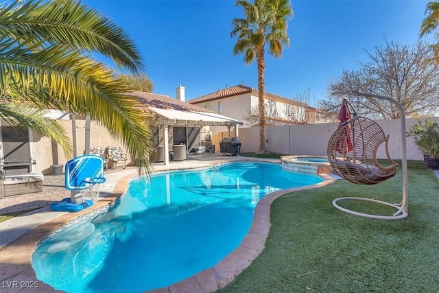 view of swimming pool with a grill, a patio area, a lawn, and an in ground hot tub