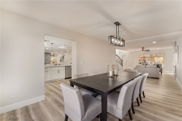 dining space with ceiling fan, sink, and light wood-type flooring