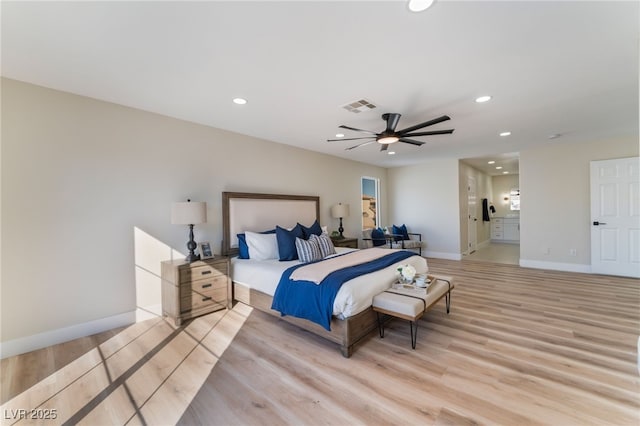 bedroom with ceiling fan, connected bathroom, and light wood-type flooring