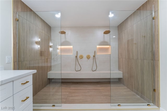 bathroom featuring a tile shower and vanity