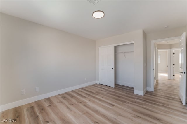 unfurnished bedroom featuring light wood-type flooring and a closet