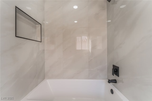 bathroom featuring tiled shower / bath