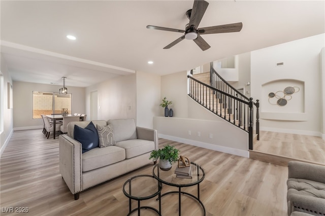 living room featuring ceiling fan and light hardwood / wood-style flooring