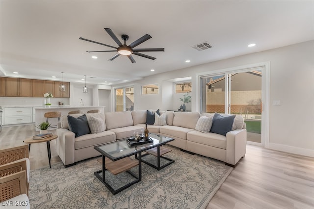 living room featuring sink and light hardwood / wood-style floors