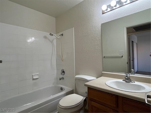 full bathroom with vanity, tiled shower / bath, and toilet