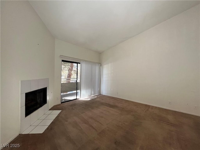 unfurnished living room with vaulted ceiling, light carpet, and a tile fireplace