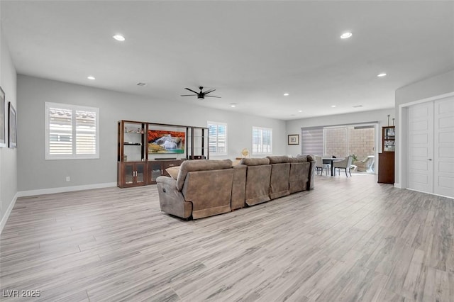 living room with ceiling fan and light hardwood / wood-style flooring