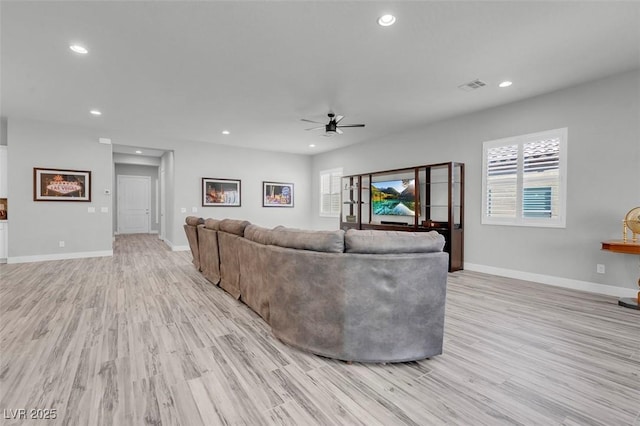 living room featuring ceiling fan and light hardwood / wood-style floors