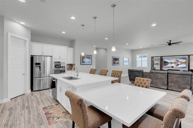 dining area featuring ceiling fan, sink, and light hardwood / wood-style flooring