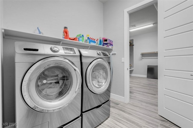 clothes washing area featuring washer and dryer and light wood-type flooring