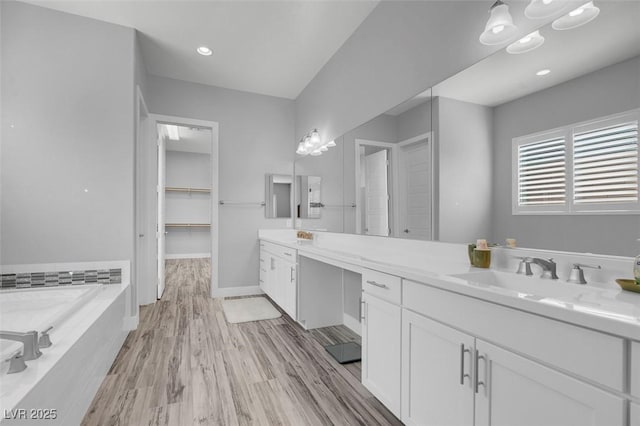 bathroom featuring vanity, hardwood / wood-style floors, and a washtub