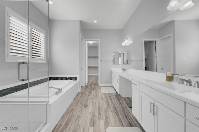 bathroom featuring plus walk in shower, hardwood / wood-style floors, and vanity