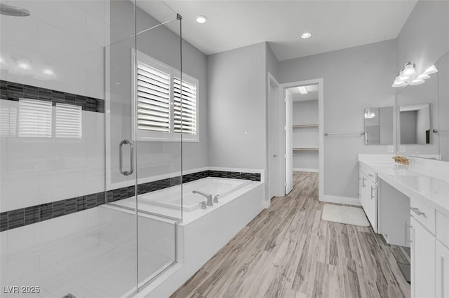 bathroom featuring independent shower and bath, vanity, and hardwood / wood-style floors