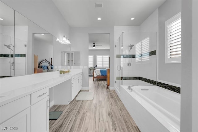 bathroom featuring hardwood / wood-style flooring, ceiling fan, vanity, and independent shower and bath