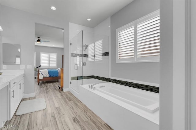 bathroom featuring vanity, separate shower and tub, hardwood / wood-style floors, and ceiling fan