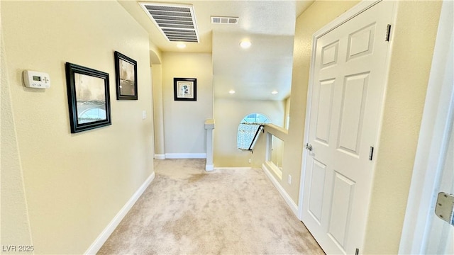 hall featuring light colored carpet