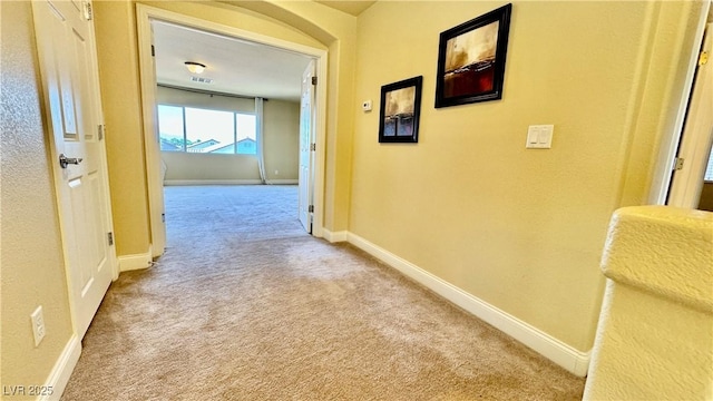 hall with light colored carpet