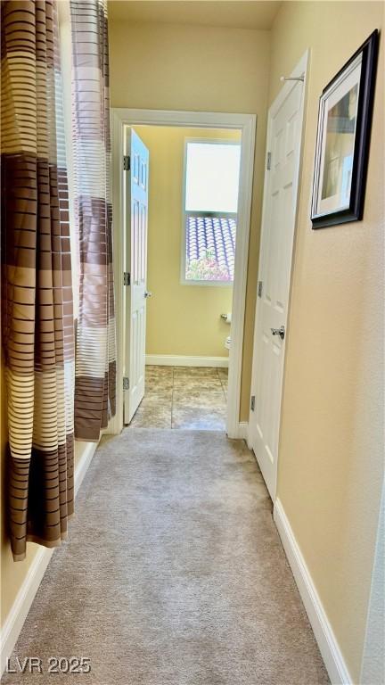 hallway featuring light colored carpet