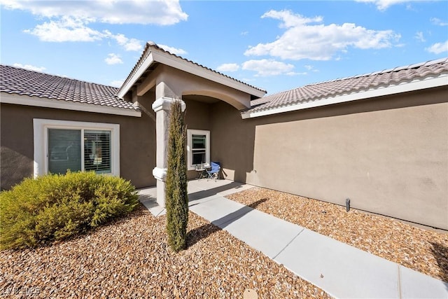 view of exterior entry featuring a patio area