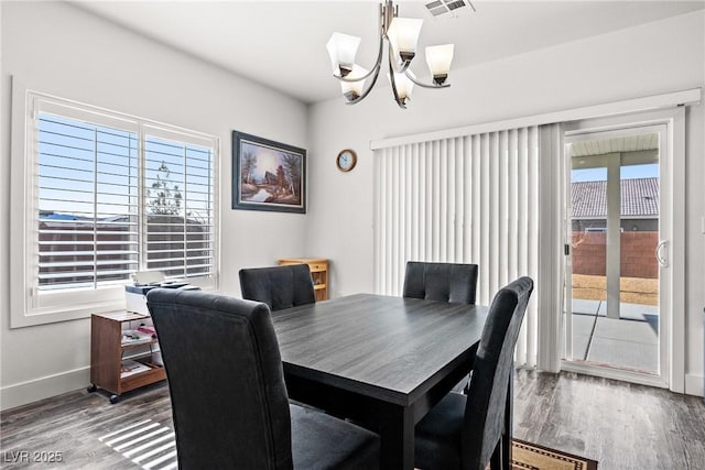 dining area with a notable chandelier and hardwood / wood-style flooring