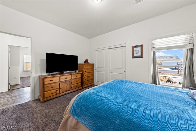 bedroom with dark colored carpet and a closet