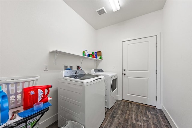 clothes washing area with dark hardwood / wood-style floors and washing machine and dryer