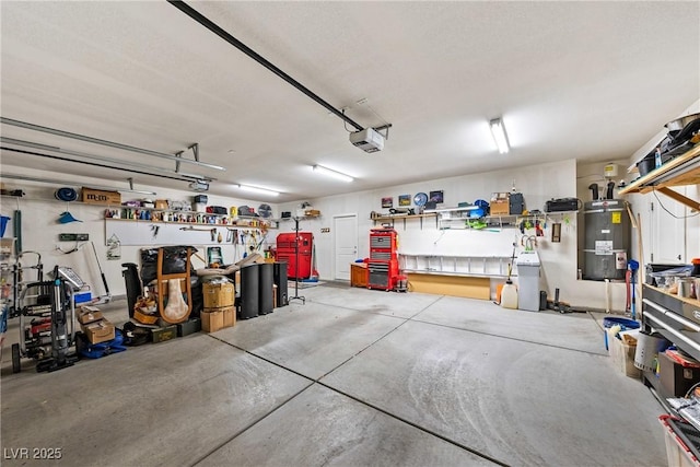 garage featuring a workshop area, a garage door opener, and strapped water heater