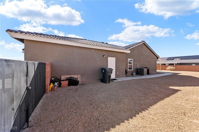 view of side of home with central AC and a patio area