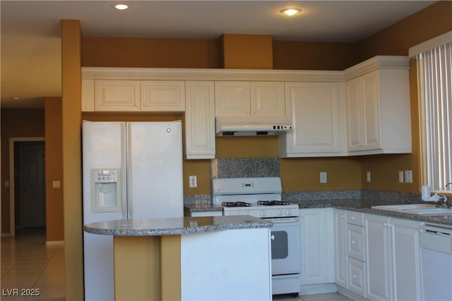 kitchen with sink, white appliances, light tile patterned floors, white cabinetry, and stone countertops