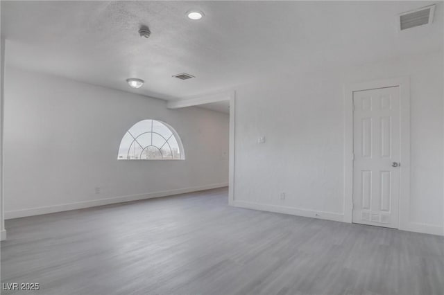 empty room featuring light hardwood / wood-style flooring and a textured ceiling