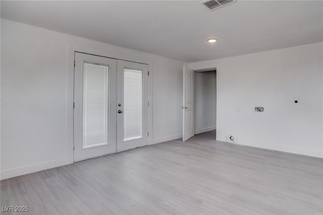 unfurnished room featuring french doors and light hardwood / wood-style flooring