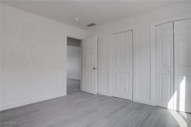 unfurnished bedroom featuring light hardwood / wood-style floors and a closet