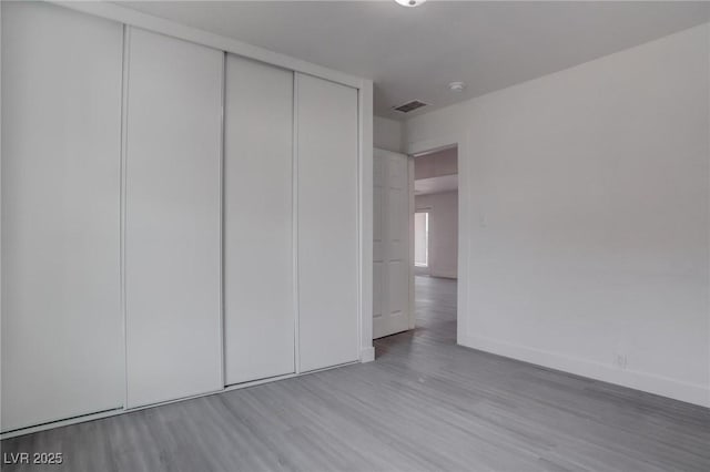 unfurnished bedroom with light hardwood / wood-style floors and a closet