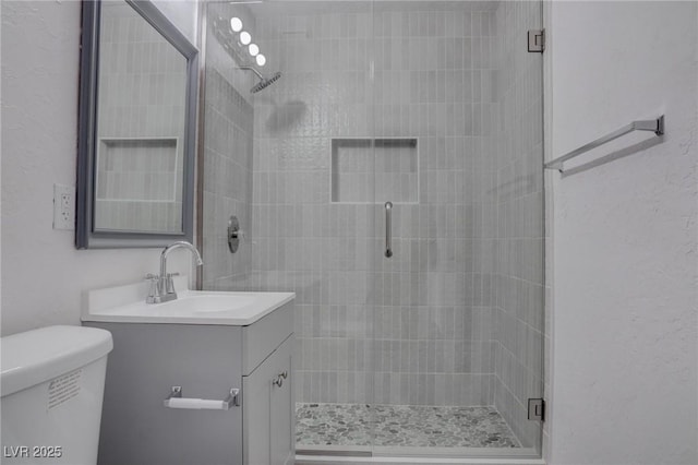 bathroom with vanity, toilet, and an enclosed shower