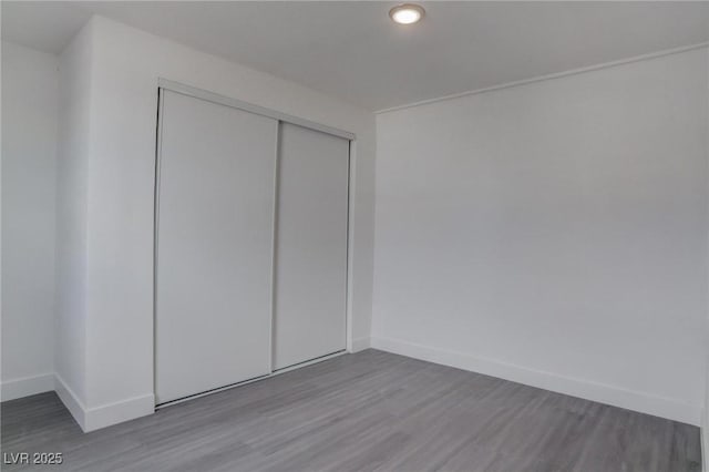 unfurnished bedroom featuring hardwood / wood-style floors and a closet