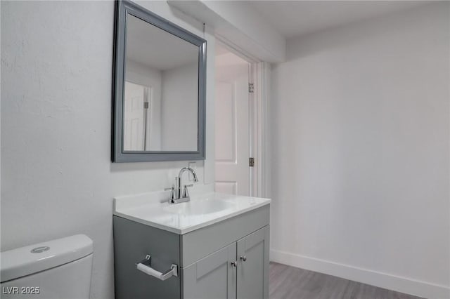 bathroom with vanity, hardwood / wood-style floors, and toilet