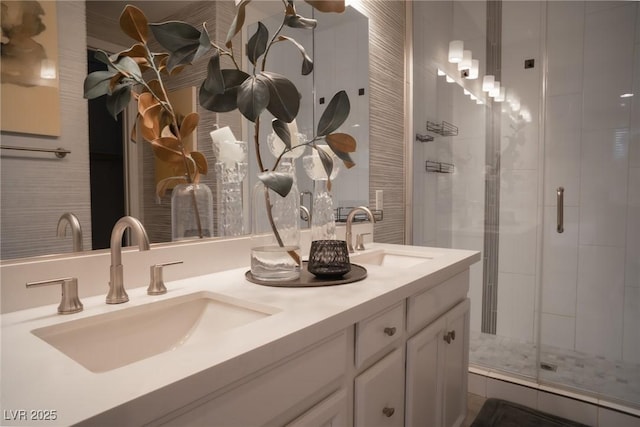 bathroom featuring a shower with shower door and vanity